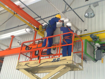 Técnicos realizando manutenção em equipamento de elevação
